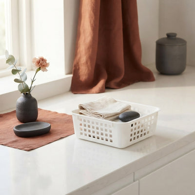 A 1-liter square storage basket on a white surface with charcoal and burnt sienna decor accents.
